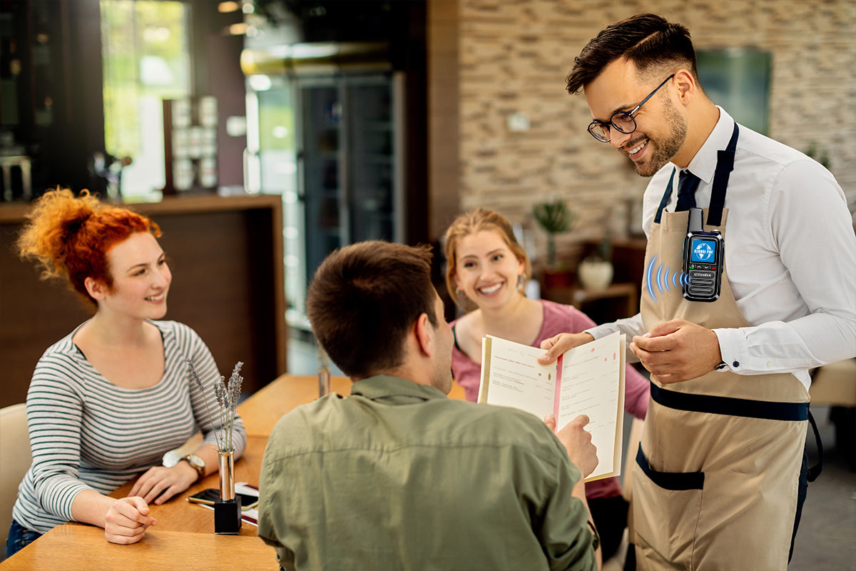 Restaurant server wearing XOTODREM 4G LTE walkie talkie on apron while taking orders from customers at dining table
